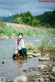 A woman sitting in the middle of a river.