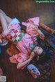 A woman in a pink kimono laying on the floor.