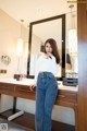 A woman standing in front of a mirror in a bathroom.