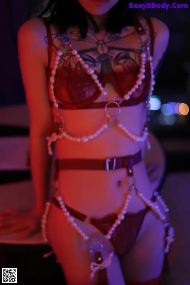 A woman in lingerie with pearls on her body. 