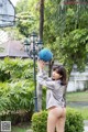 A woman holding a basketball in front of a basketball hoop.